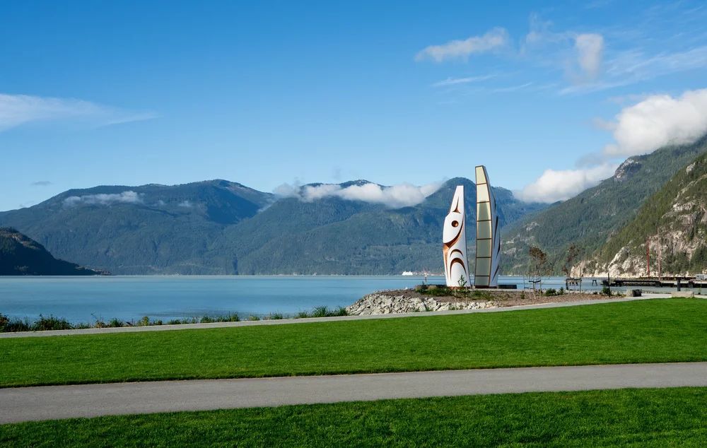 The Welcome Gate sculpture by James Harry at Squamish Oceanfront, Howe Sound beyond